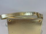a gold purse on a white table with a white background