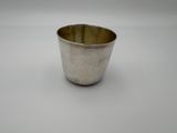 an old silver cup on a white surface with a white background