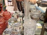 a man taking a picture of a glass vase on a table