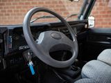 a steering wheel and dashboard of a car with a brick wall in the background