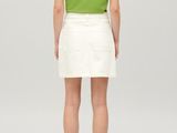 a woman in a green shirt and white skirt is looking back