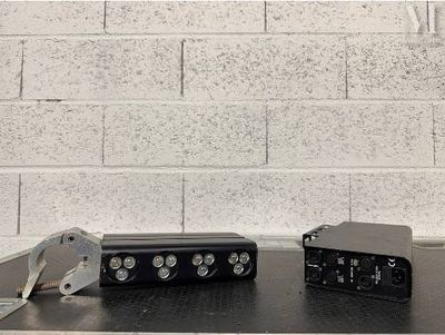 deux appareils électroniques posés sur une table près d'un mur en briques
