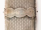 an antique silver cigarette case with a woven design on the front