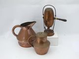 three different types of copper pitchers on a white surface