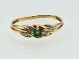a close up of a gold ring with a green stone on it