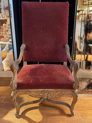red velvet upholstered chair in front of a store window