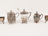a group of silver and glass items including a teapot, cup, and spoon
