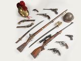 de nombreux types d'armes à feu et d'autres objets posés sur la table