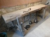 un banc en bois sur lequel sont posés des outils, dans une pièce