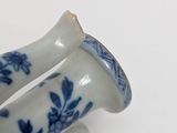 two blue and white vases sitting on a white surface