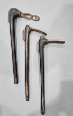 three old tools that are hanging on the wall