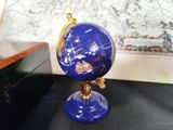 a blue and gold globe sitting on a black table