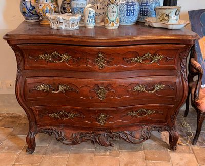 une commode sur laquelle sont posés de nombreux vases