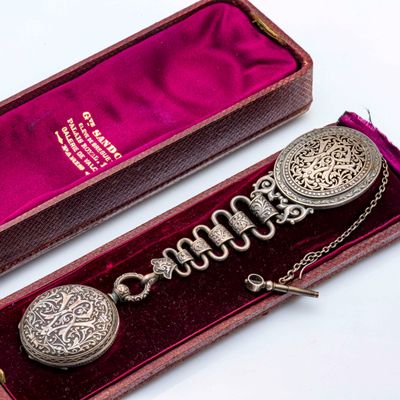 une montre de poche en argent dans un écrin, avec une chaîne