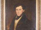 portrait of a man in a black coat in a gold frame on a red wall