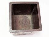a small square metal container on a white surface