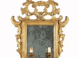 un miroir à cadre doré sur lequel est posé un bougeoir
