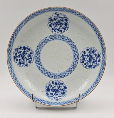 une photo d'une assiette bleue et blanche posée sur un support