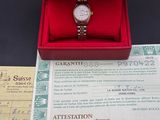 a red box with a watch inside of it on a table