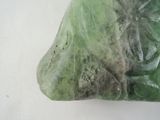 a piece of green marble on a white surface