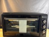 a toaster oven sitting on a table with a note taped to it