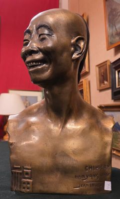 un buste en bronze représentant un homme souriant