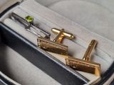 deux boutons de manchette en or dans un étui orné d'une paire de ciseaux