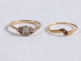 two gold rings with a grey stone and a red stone