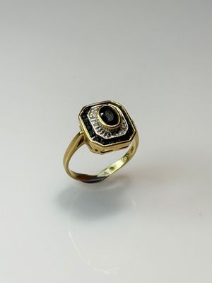 a close up of a gold ring with a black and white stone