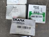 trois cartons contenant des skateboards assortis, posés sur une surface en béton