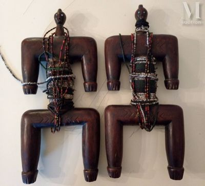 deux figurines en bois accrochées à un mur