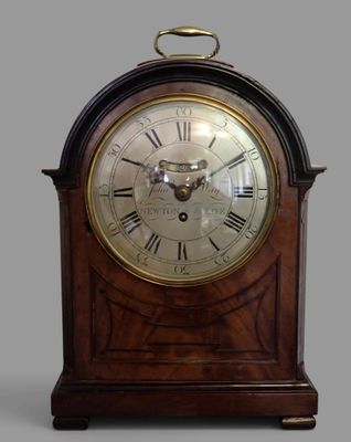 une horloge en bois avec des chiffres romains sur le cadran