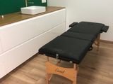 une photo d'une pièce avec une table de massage et un lavabo