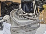 an old air compressor sitting on top of a table next to other items