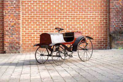 a small toy horse and carriage on a brick floor