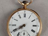 a gold pocket watch with roman numerals on it