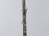a close up of a clarinet on a clear stand against a white background