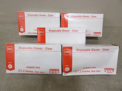 Trois boîtes de gants jetables sont posées sur une table