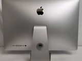 a silver apple computer sitting on a white surface