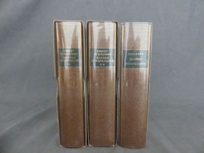 trois livres sont empilés sur une table