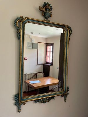a mirror on the wall reflecting a dining room table
