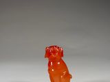 an orange gummy bear sitting on a white surface