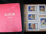 un album rose posé sur une table à côté d'un livre rose
