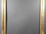 a gold framed mirror with a black background