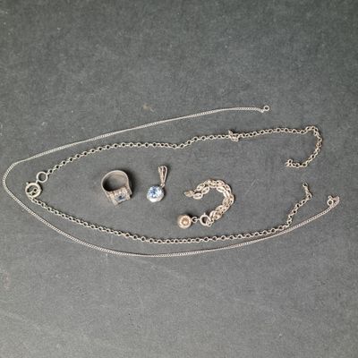 un collier, une bague et une boucle d'oreille posés sur une table