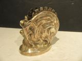 a gold sculpture of a lion head on a table
