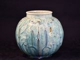 un vase bleu posé sur une surface noire