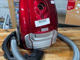 un aspirateur rouge posé sur une table en bois