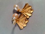 a gold brooch with pearls on it on a table