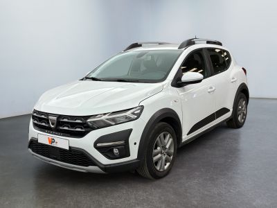 La voiture blanche est garée dans une pièce au sol noir.